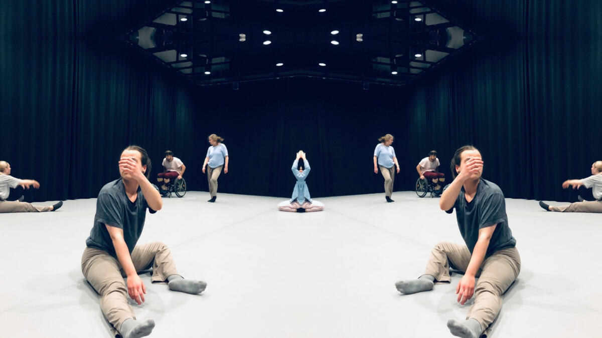 Useita ihmisiä ympäri esitystilaa.